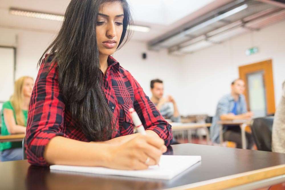 Student taking notes at her desk