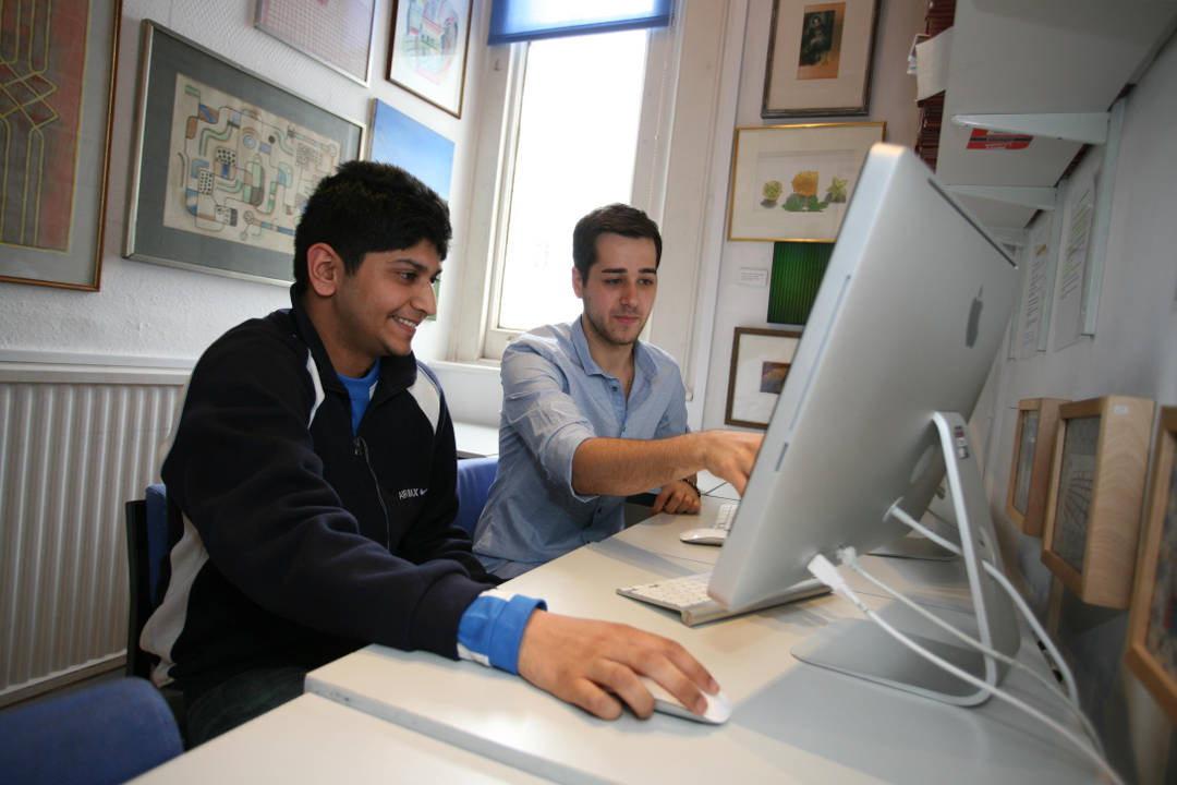 Student and teacher researching on computer